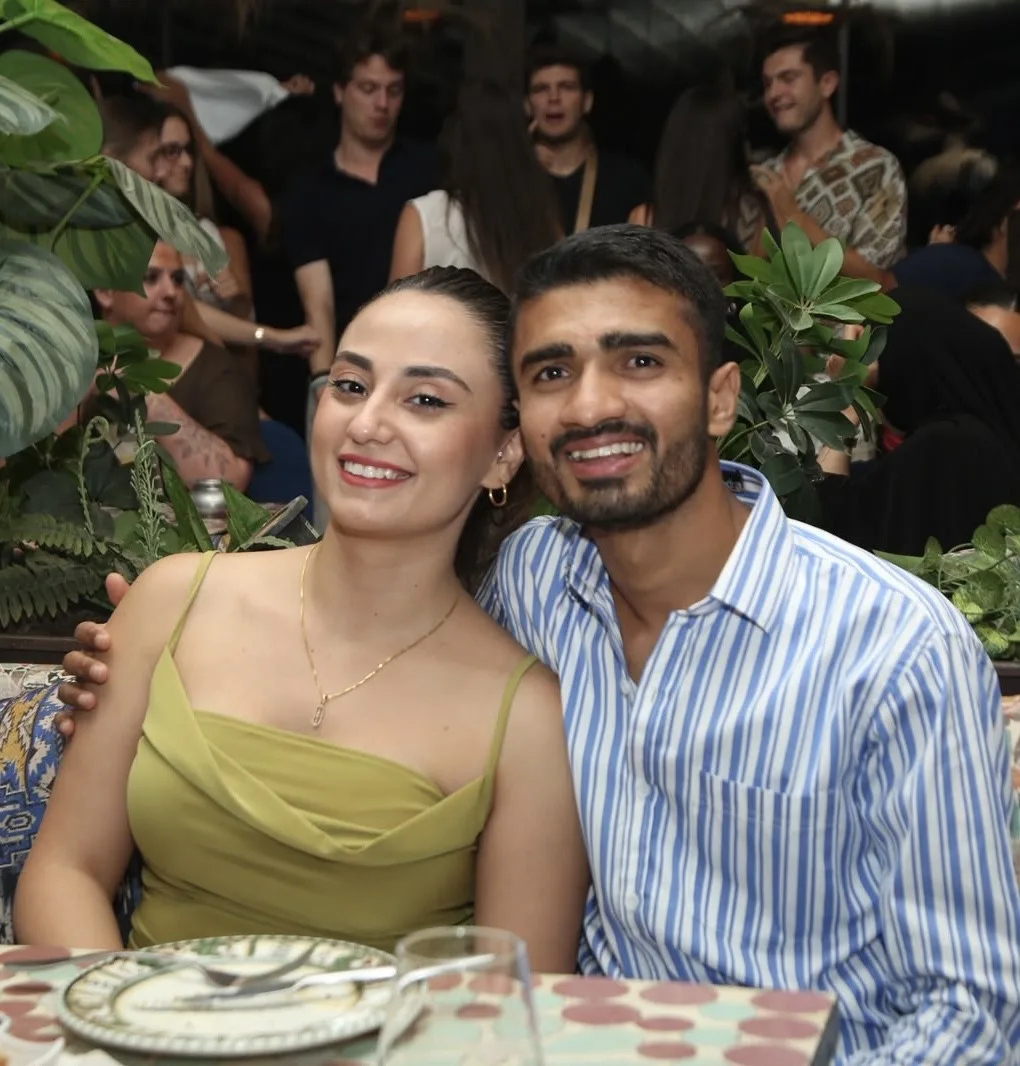 Meleknaz ve Om Gauswami restoranda bir masada gülümsüyor